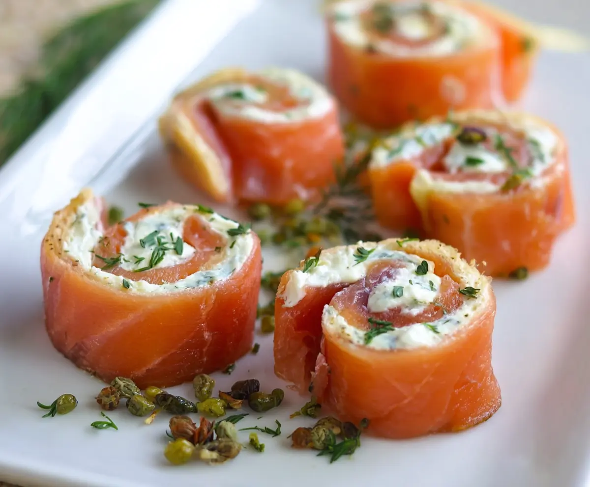Delicious smoked salmon pinwheels filled with cream cheese and fresh herbs, perfect for appetizers.