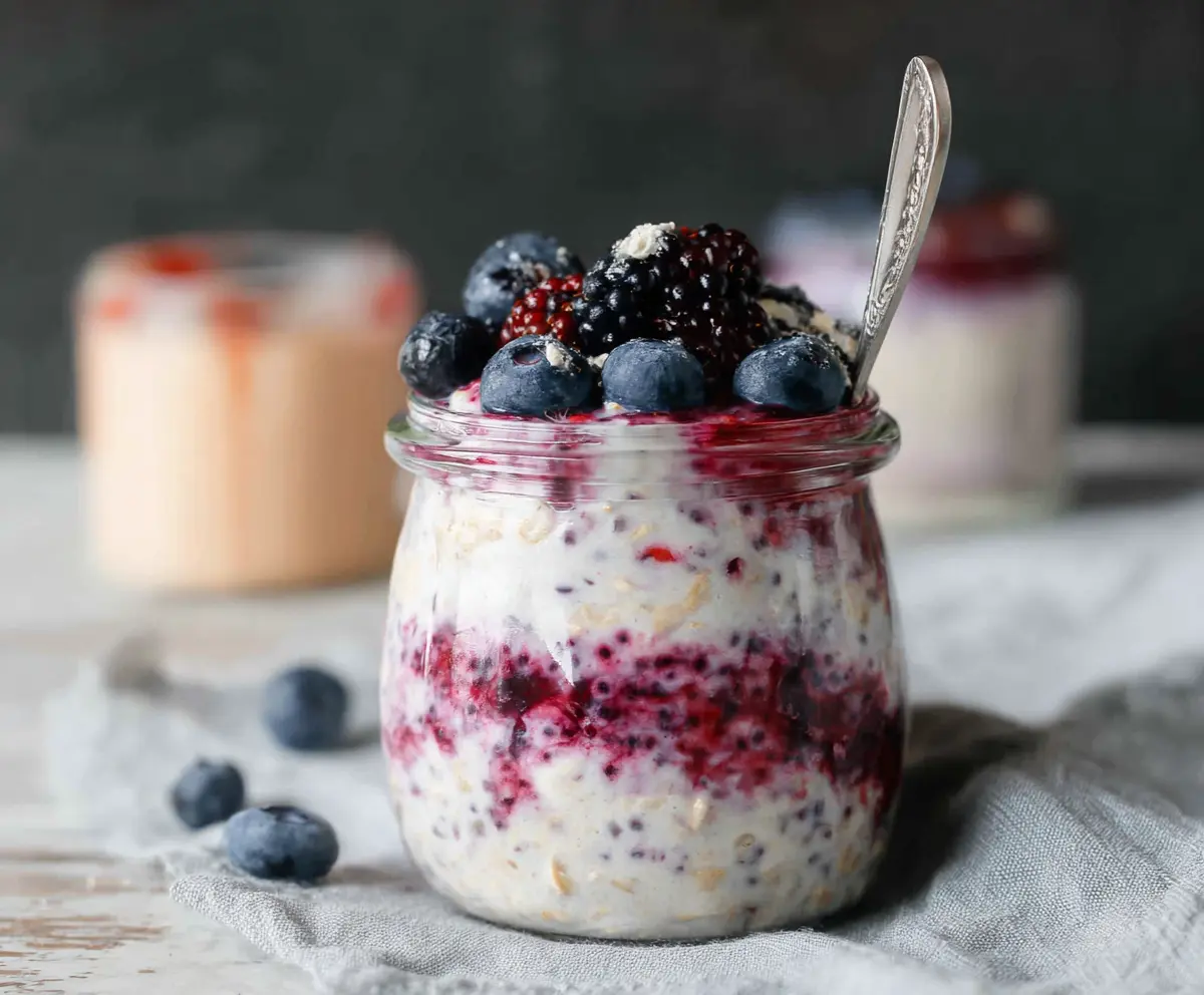 Delicious Berry Cheesecake Overnight Oats topped with fresh berries and creamy cheesecake filling