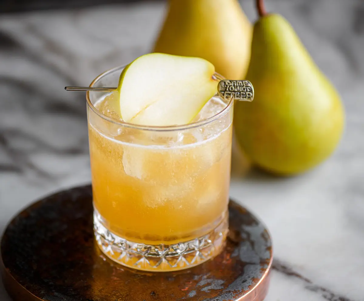 Refreshing Ginger Pear Bourbon Cocktail served in a glass with fresh ginger and pear garnish.