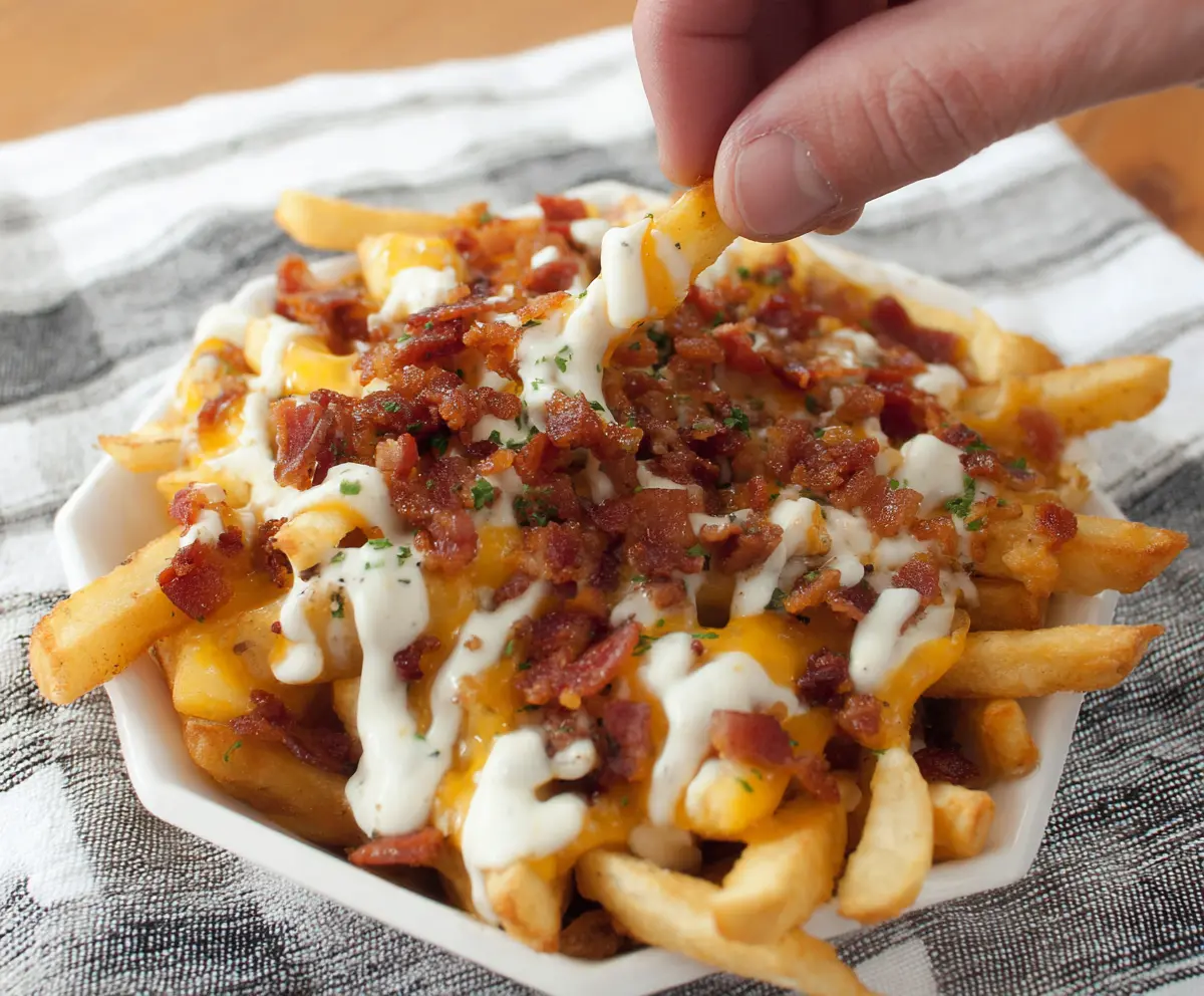 Delicious Loaded Bacon Ranch French Fries topped with crispy bacon, melted cheese, and fresh herbs.