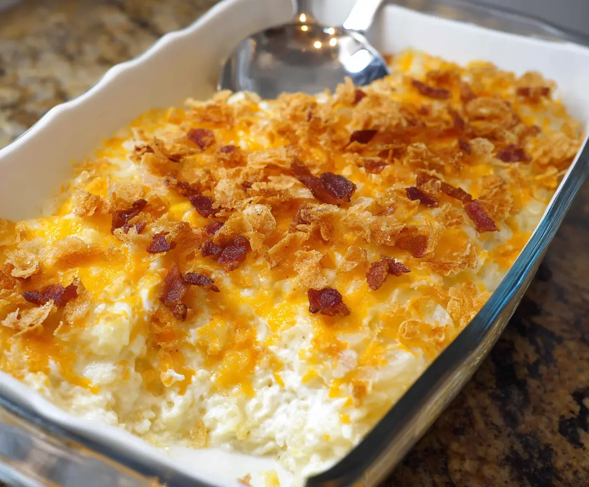Delicious cheesy baked potato casserole topped with melted cheese and fresh herbs.