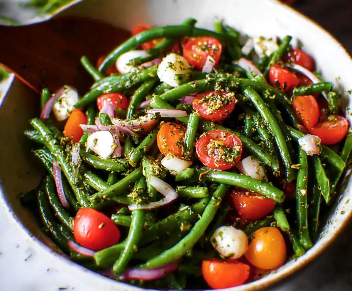 Fresh green bean salad with cherry tomatoes and feta cheese, perfect for summer meals.