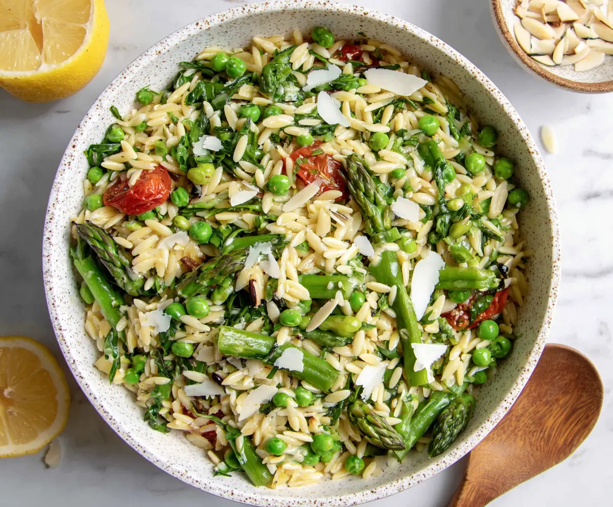 Colorful spring orzo pasta salad with fresh vegetables and herbs, perfect for health-conscious meals.